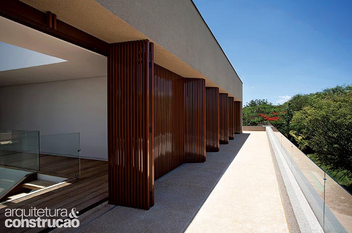 No primeiro pavimento, o terraço passeia por todos os dormitórios, oferecendo visão privilegiada do panorama. O fechamento é um brise inteiriço, de ponta a ponta, de alumínio com pintura de efeito madeira (Metal-Lar). (Marco Antonio)